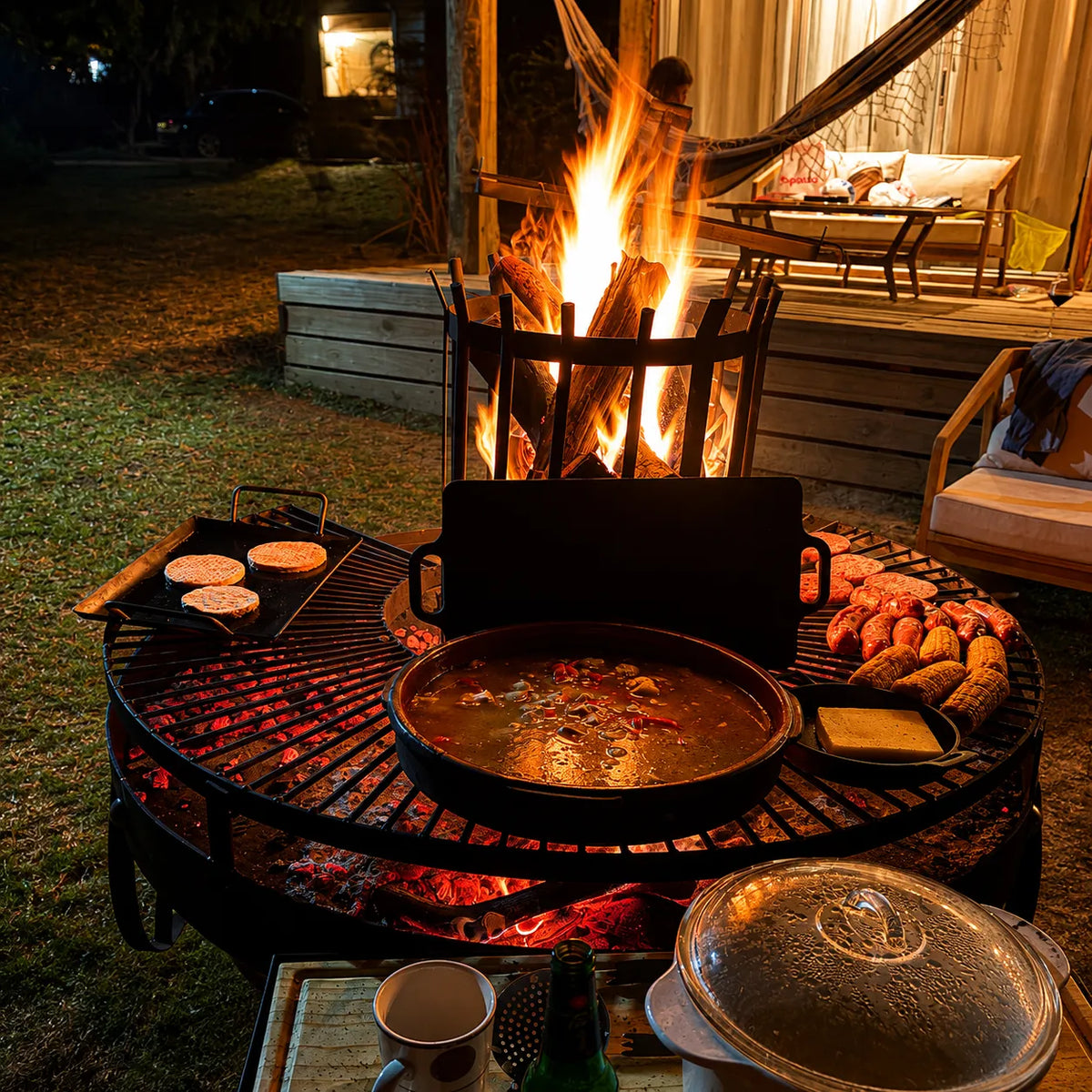 Fogón Criollo 120 encendido de noche, con la brasa pareja y varias piezas sobre la parrilla