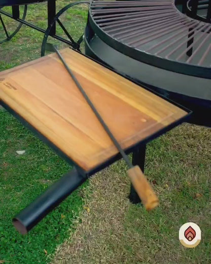 Video del Fogón Criollo 90 de hierro con parrilla, ruedas y tabla de madera, en un jardín