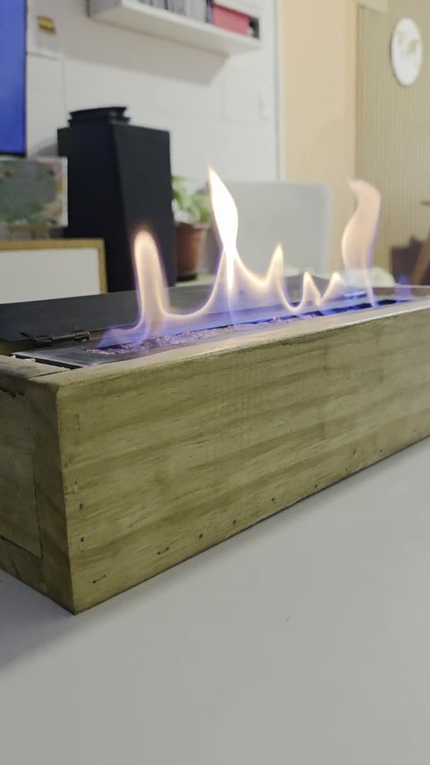 Video de la estufa decorativa de bioetanol 25 cm encendida, con cajón de madera, sobre una mesa